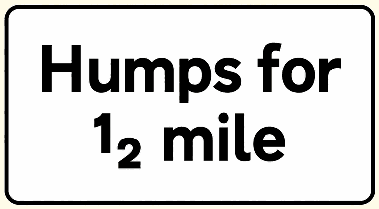 White rectangular plate reading “Humps for ½ mile”: the distance panel fitted under a road-hump warning sign.