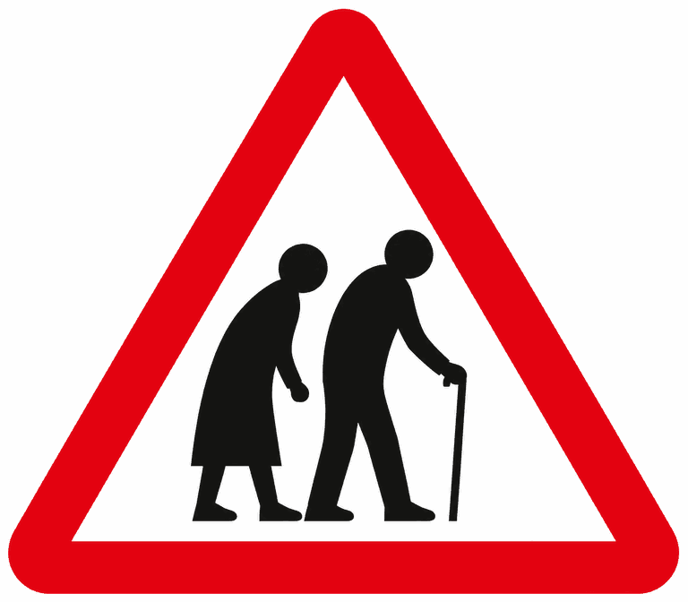 Red-bordered warning triangle showing two stooped older people, the one in front using a walking stick: elderly people may be crossing.